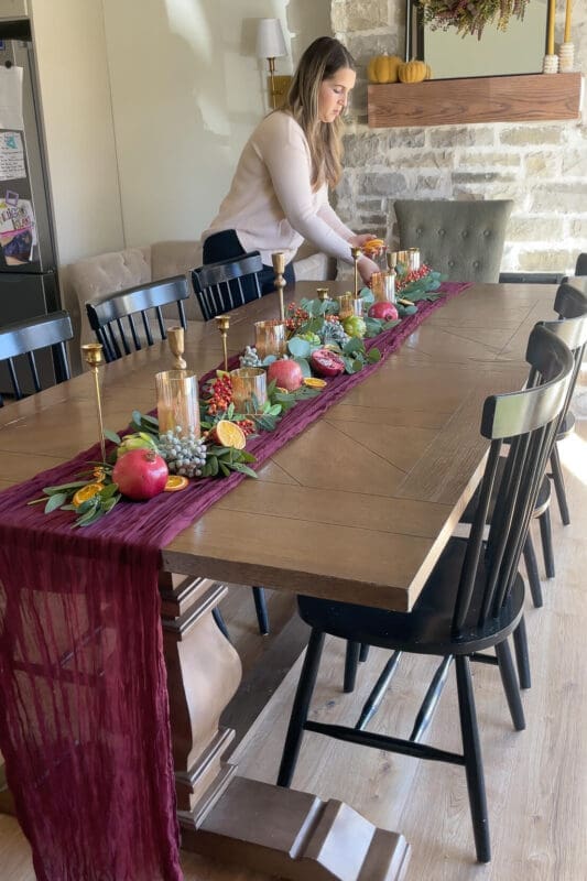 Placing dried orange slices along the burgundy runner